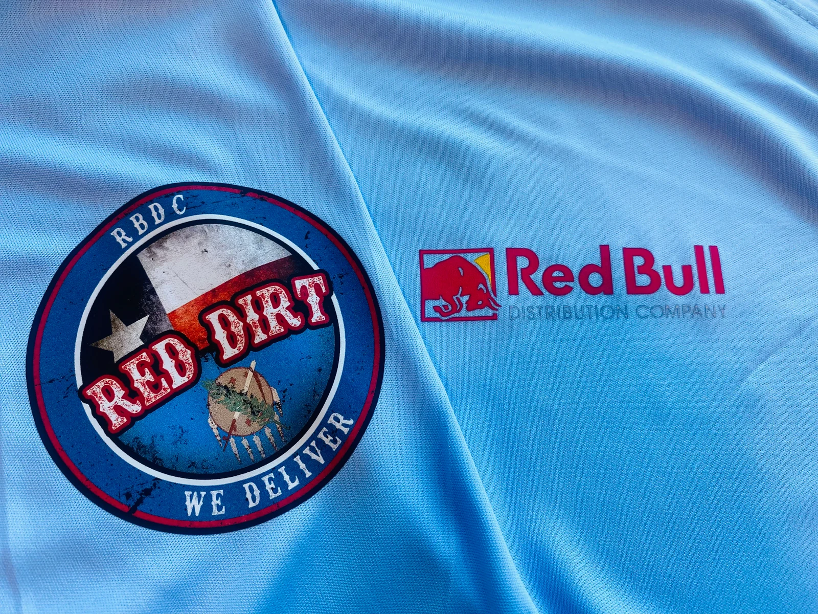 Close-up of custom branded logo applications on light blue fabric produced by Satellite PrintLab in Austin